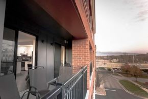 Rochester apartment for rent - A balcony with a table and chairs overlooks a street.