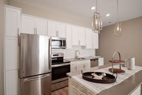 Rochester Hills apartment for rent - A modern kitchen with a stainless steel refrigerator and white cabinets.