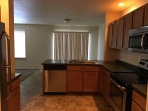 Stanley apartment for rent - A kitchen with wooden cabinets and a black countertop.