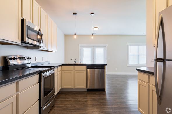 Stanley apartment for rent - A kitchen with wooden cabinets and black countertops.