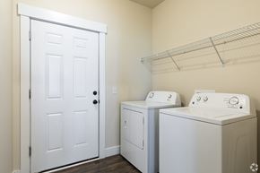 Stanley apartment for rent - A white door is on the left of two washing machines.