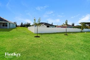 Cape Coral house for rent - the backyard of a house with two trees and a fence