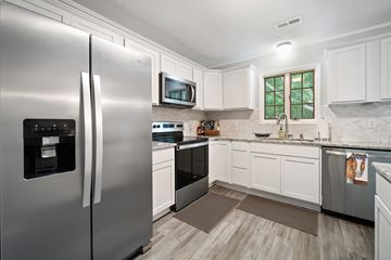 Jacksonville house for rent - A modern kitchen with a stainless steel refrigerator and white cabinets.