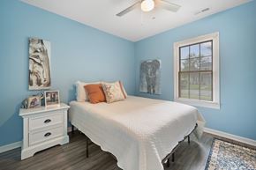 Jacksonville house for rent - A bedroom with a white bed and a blue wall.
