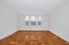 Washington apartment for rent - A room with a wooden floor and a window with a view of trees.