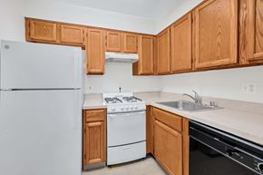 Washington apartment for rent - A kitchen with wooden cabinets and a white refrigerator.
