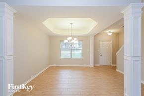 Winston Salem house for rent - an empty dining room with wood floors and a window
