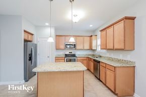 Winston Salem house for rent - a kitchen with wooden cabinets and granite counter tops