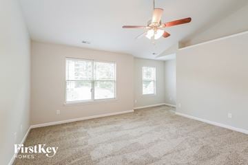 Winston Salem house for rent - a spacious living room with carpet and a ceiling fan