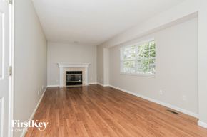 Maineville house for rent - A room with a fireplace and wooden floors.
