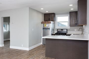 Lemon Grove house for rent - A kitchen with brown cabinets and a white counter.