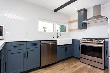 San Diego house for rent - a kitchen with blue cabinets and stainless steel appliances