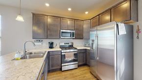 Crown Point house for rent - A kitchen with a refrigerator, sink, and stove.
