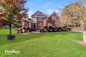 Whitsett house for rent - A large brick house with a tree in front of it.