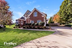Whitsett house for rent - A brick house with a lawn in front of it.
