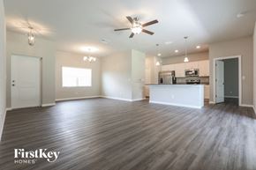 Port Charlotte house for rent - an empty living room with a ceiling fan and a kitchen