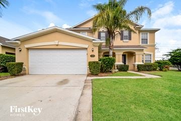 Jacksonville house for rent - a yellow house with a white garage door and a palm tree