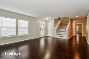 Jacksonville house for rent - an empty living room with wood floors and a staircase