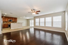 Jacksonville house for rent - an empty living room and kitchen with a ceiling fan