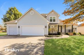 Raymore house for rent - a white house with a white garage door and a lawn