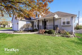 Raymore house for rent - a white house with a lawn and a sidewalk in front of it