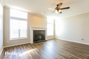 Raymore house for rent - a living room with a fireplace and a ceiling fan