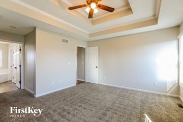 Raymore house for rent - a living room with carpet and a ceiling fan