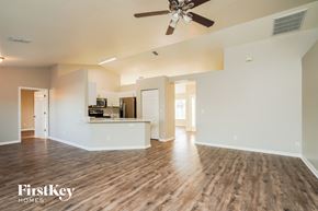 Cape Coral house for rent - A spacious living room with a ceiling fan and hardwood floors.
