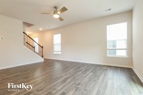 Simpsonville house for rent - A spacious room with a wooden floor and a ceiling fan.