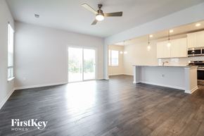 Simpsonville house for rent - A spacious room with a kitchen area and a ceiling fan.