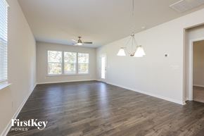 Greer house for rent - A spacious room with wooden floors and a ceiling fan.