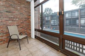 Louisville apartment for rent - A chair is placed on a balcony with a glass door.