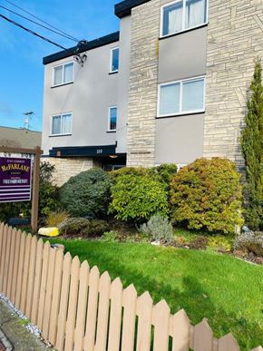 Nanaimo apartment for rent - A McFarlane sign is in front of a grey building.