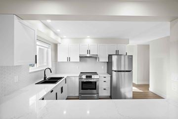 Nanaimo apartment for rent - A modern kitchen with white cabinets and stainless steel appliances.