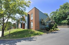 Louisville apartment for rent - A modern building with a grey roof and a green lawn in front.
