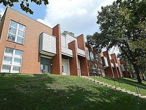 Louisville apartment for rent - A red brick building with a green lawn in front.