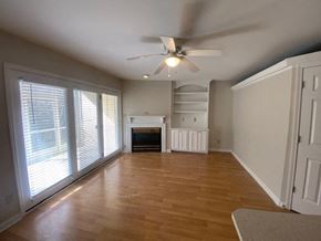 Louisville apartment for rent - A room with a fireplace and a ceiling fan.