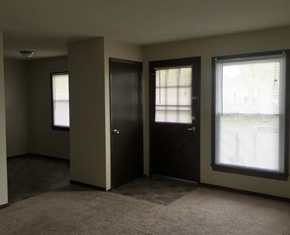 Highland apartment for rent - an empty living room with a door and two windows