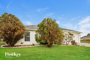 Cape Coral house for rent - a white house with a lawn and two trees