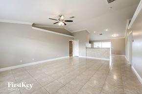 Cape Coral house for rent - a spacious living room with tile flooring and a ceiling fan