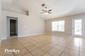 North Port house for rent - A spacious room with a ceiling fan and tile flooring.