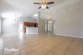 North Port house for rent - A spacious room with a ceiling fan and tiled flooring.