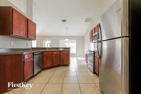 North Port house for rent - A kitchen with wooden cabinets and a stainless steel refrigerator.
