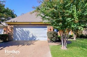 Memphis house for rent - A house with a garage door and a tree in front.
