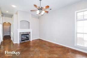 Memphis house for rent - A room with a fireplace and a ceiling fan.
