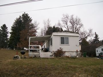 Pullman apartment for rent - A white house with a porch and a car parked in front.