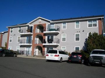 Pullman apartment for rent - A white car is parked in front of a grey apartment building.