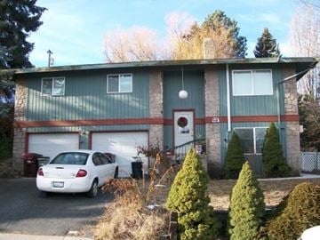 Pullman apartment for rent - A white car is parked in front of a green house.