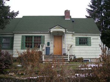 Pullman apartment for rent - A white house with a green roof and a brown door.