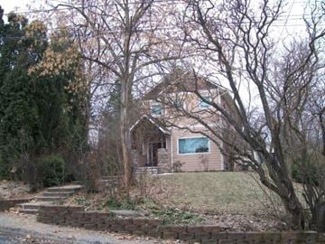 Pullman apartment for rent - A house with a green roof is surrounded by bare trees.